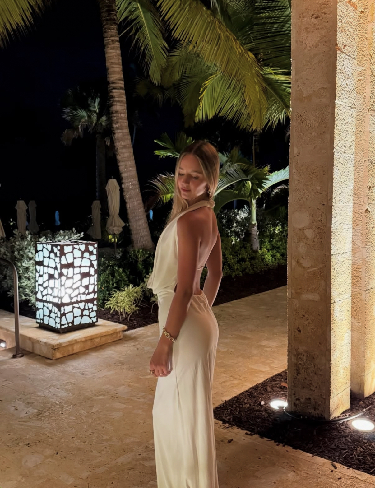 Katelyn at an evening event, beside warm decorative lighting